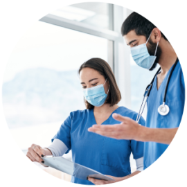 Photo of two masked physicians looking at clipboard
